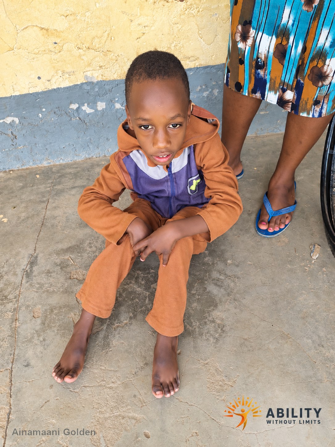 Ainamaani Golden seated outside his home